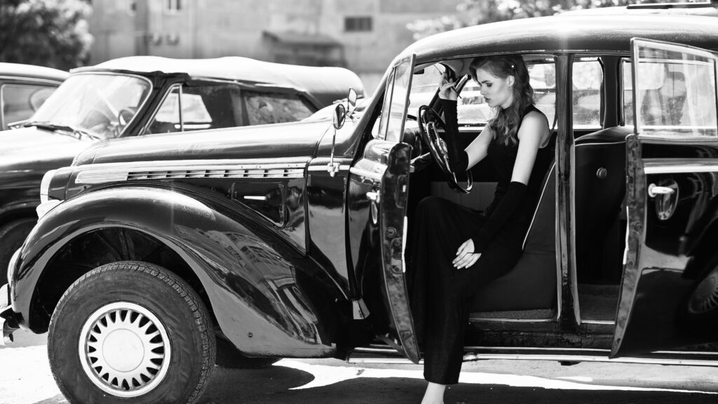 Vintage car with elegantly dressed woman at Concours of Elegance
